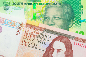 A macro image of a shiny, green 10 rand bill from South Africa paired up with a brown ten thousand bank note from Colombia.  Shot close up in macro.