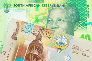 A macro image of a shiny, green 10 rand bill from South Africa paired up with a colorful, plastic quarter dinar from Kuwait.  Shot close up in macro.