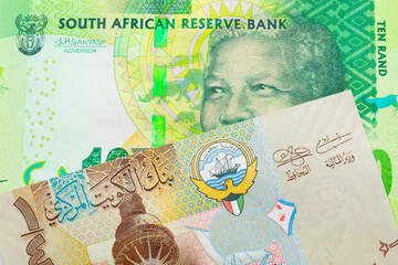 A macro image of a shiny, green 10 rand bill from South Africa paired up with a colorful, plastic quarter dinar from Kuwait.  Shot close up in macro.