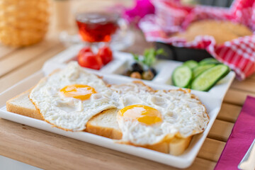 Fried eggs sunny side up on bread with side dishes. Breakfast of sunny side up eggs. Weekend breakfast concept with sunny side up eggs