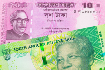 A macro image of a shiny, green 10 rand bill from South Africa paired up with a pink ten taka bank note from Bangladesh.  Shot close up in macro.