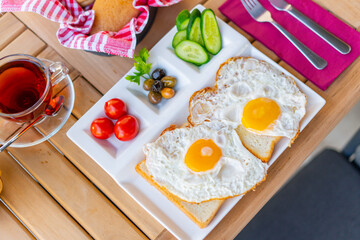 Fried eggs sunny side up on bread with side dishes. Breakfast of sunny side up eggs. Weekend breakfast concept with sunny side up eggs