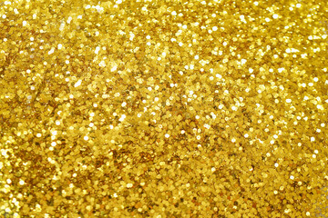 Gold defocused glitter.  Bokeh light of gold glitters background. 