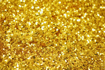 Gold defocused glitter.  Bokeh light of gold glitters background. 