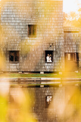 Fanciful wooden building in the middle of the park in autumn with a happy couple inside