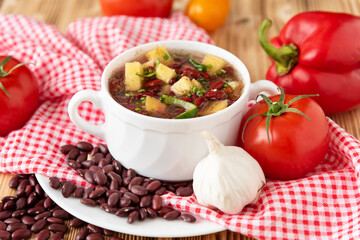 Bean soup with meat in a white ceramic bowl.