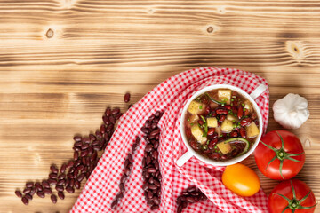 Red bean soup with potatoes, tomatoes and paprika in a ceramic bowl. Top view.