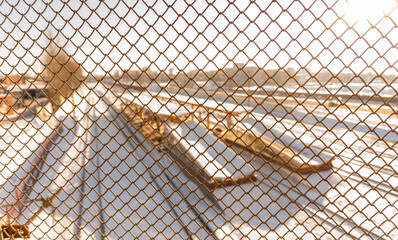 View through the lattice of the railway station and the train tracks, life behind bars