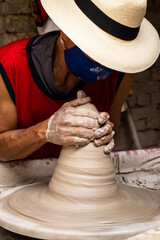 Man making ceramic articles on the pottery wheel in a traditional factory in the city of Ráquira located in the department of Cundinamarca in Colombia