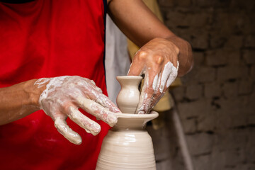 Man making ceramic articles on the pottery wheel in a traditional factory in the city of Ráquira located in the department of Cundinamarca in Colombia