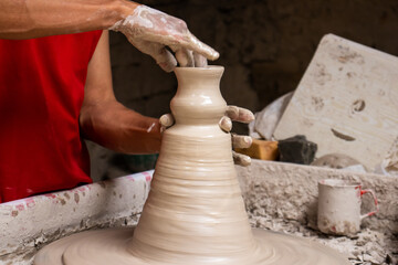 Man making ceramic articles on the pottery wheel in a traditional factory in the city of Ráquira located in the department of Cundinamarca in Colombia
