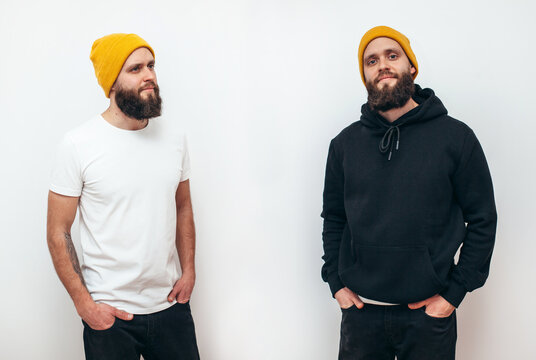 Collage of photos with young handsome bearded hipster guy wearing black blank hoodie and white blank t-shirt . Two guys in empty white tshirt and black hoodie isolated on white background
