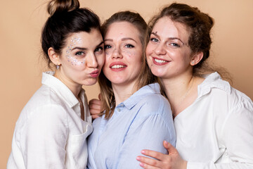 happy and overweight multicultural women in bras isolated on beige. Diverse Beauty. Three Multiethnic Ladies Wrapped In Bath Towels Posing Smiling At Camera On Beige Background. Studio Shot