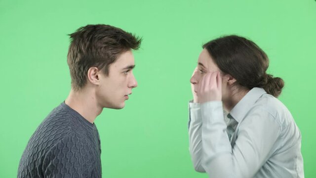 Quarrel of a couple of newlyweds. Young guy beautiful girl yelling at each other. Domestic violence, slap in the face. The concept of relationships. Chroma key.