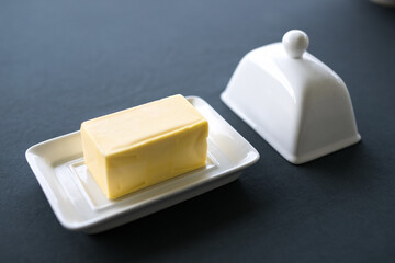 Block of butter on ceramic plate in kitchen