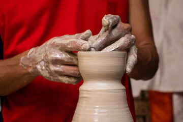 Man making ceramic articles on the pottery wheel in a traditional factory in the city of Ráquira located in the department of Cundinamarca in Colombia