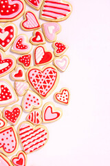 assortment of homemade heart shaped valentines sugar cookies with red, pink, and white icing designs