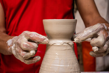 Man making ceramic articles on the pottery wheel in a traditional factory in the city of Ráquira located in the department of Cundinamarca in Colombia