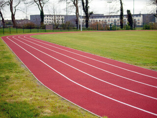 Brand new track for running. Red color, nobody. Outdoor activity and sport concept.