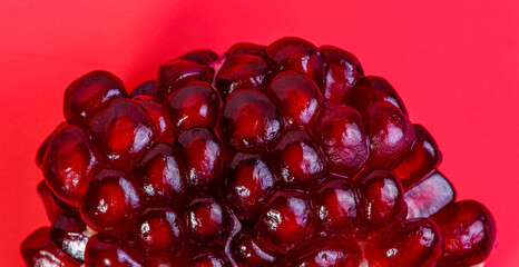 A macro shot of pomegranate seeds with a red background