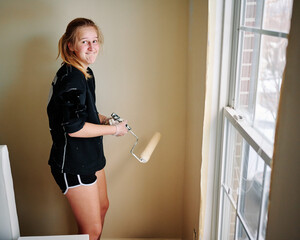 DYI (do it yourself) room painting. Father and daughter doing home renovation. They painted the room walls with pretty yellow color and got covered with paint splashes in the process.