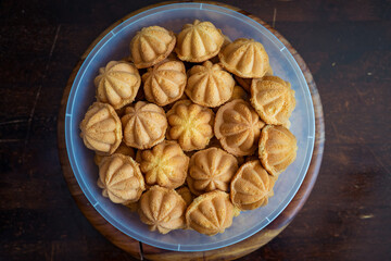 Kuih Bahulu, baulu or bolu in a container. Sponge cake baked in special aluminium moulds is the Asian tradition food in popular Malaysia and Indonesia.