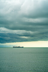 Seaview with ships in Port Dickson. Heavy clouds in rainy season. The image contain soft focus, noise and grain.