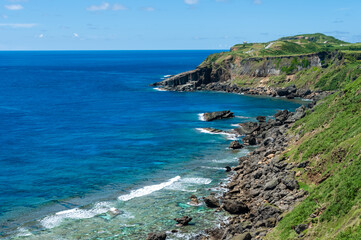 Impressive transparent blue sea seen from a cliff where you can see a lush coral reef, rocks formation and a breathtaking horizon. Yonaguni Island.
