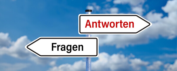 street signs pointing in opposing directions with the German message for QUESTIONS and ANSWERS in...