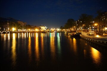 Fototapeta na wymiar Amsterdam's canals iluminated at night