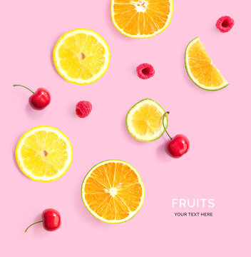 Creative layout made of lemon, orange, cherry and raspberry on pink background. Tropical summer flat lay. Food concept.