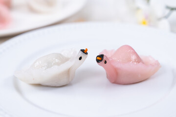 Two Chinese Har Gao Dim Sum dumplings in the shape of a swan, red and white color