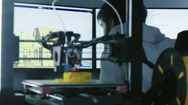 3d Printer printing yellow small house with engineer constructor in background at pc model shot in 4k