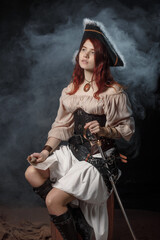 Fototapeta premium Woman is wearing black corset bustier, tricorn hat, gun belt and armed with pistol and sword