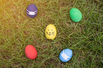 Fototapeta na wymiar Easter eggs wearing mask for Easter holidays. prevention of coronavirus or covid-19, Easter eggs wearing mask on grass.