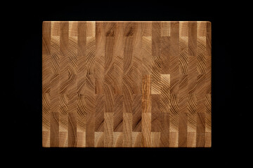 Mosaic texture of oak planks.  Oak plank mosaic wooden chopping board on black background.