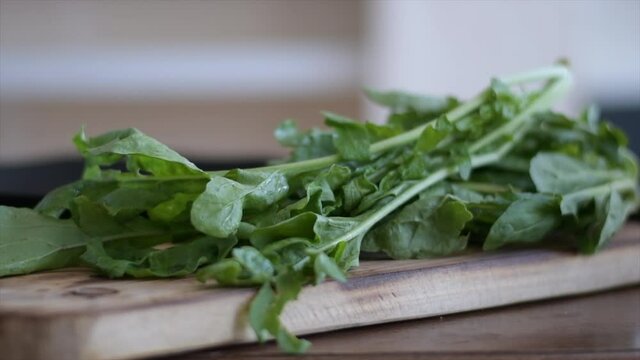 package of fresh green arugula on wooden base