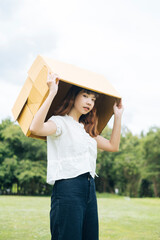 Obraz premium Hipster woman playing cardboard box putting it over head.