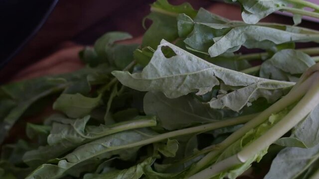 package of fresh green arugula on wooden base