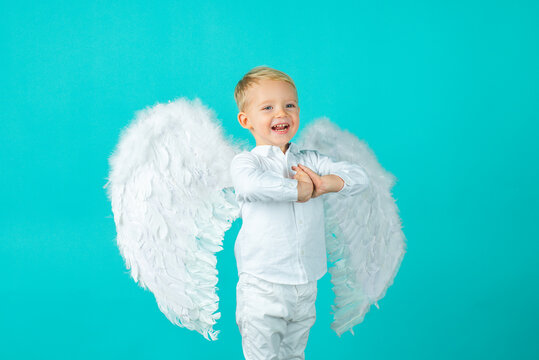 Cute baby child with angel wings, isolated on blue.