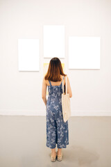 Young asian thai woman in blue dress in white art gallery.