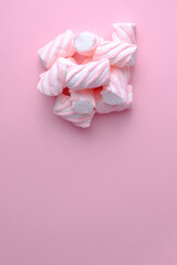 Fototapeta na wymiar Stack of pink and white marshmallows on pink background with copy space