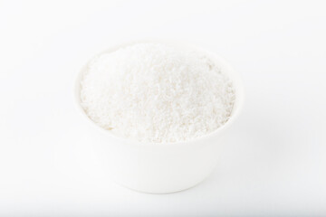 Fototapeta na wymiar Fresh coconut flakes in white bowl isolated on white background.