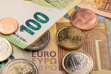 Closeup of Euros, coins and banknotes. One hundred Euro bill on top of two hundred Euro banknote. European central Bank currency