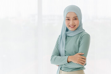Portrait of 30s beautiful Muslim girl wearing hijab traditional religious cloth use hand touch her...