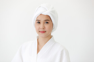 Portrait of middle age Asian woman with towel-covered around her head in the spa. She is smiling and looking at camera. Idea for female who care for health and skin