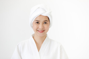 Portrait of middle age smiling beautiful Asian woman with towel-covered around her head in the spa pose and looking at camera. Idea for female who care for health and skin
