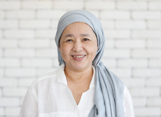 Portrait of an Asian woman with a clothe covered head and smile with happiness to the camera....