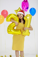 Young and beautiful Asian women wearing colorful party dresses enjoying and happy to celebrate the time. She holding golden number of 21.