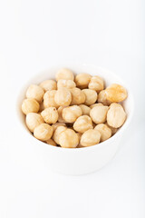 Bowl with hazelnuts over white background
